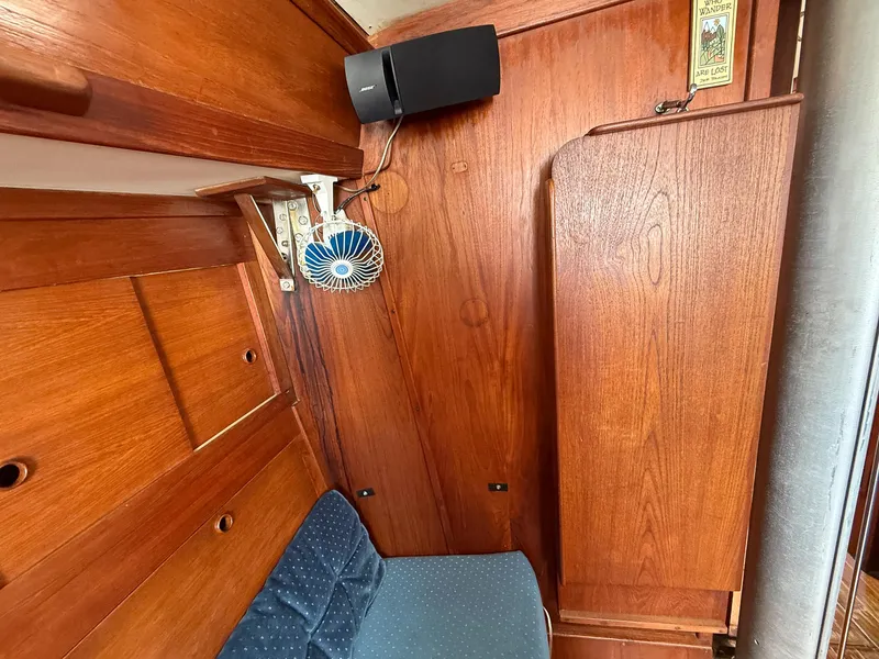 Slide: The Image of Interior of 1982 Tartan 37 sailboat with wooden paneling and blue cushioned seating. - 35