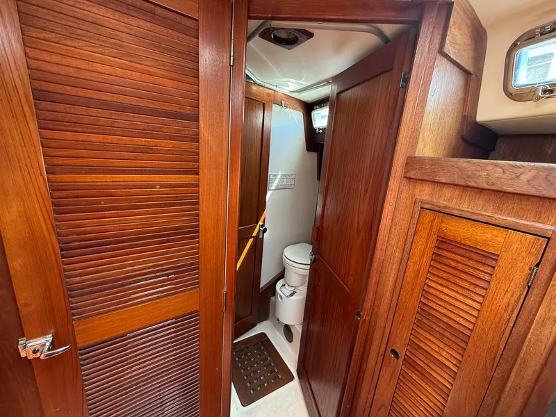 Slide: The Image of 1982 Tartan 37 yacht bathroom with wooden cabinetry and compact toilet. - 42