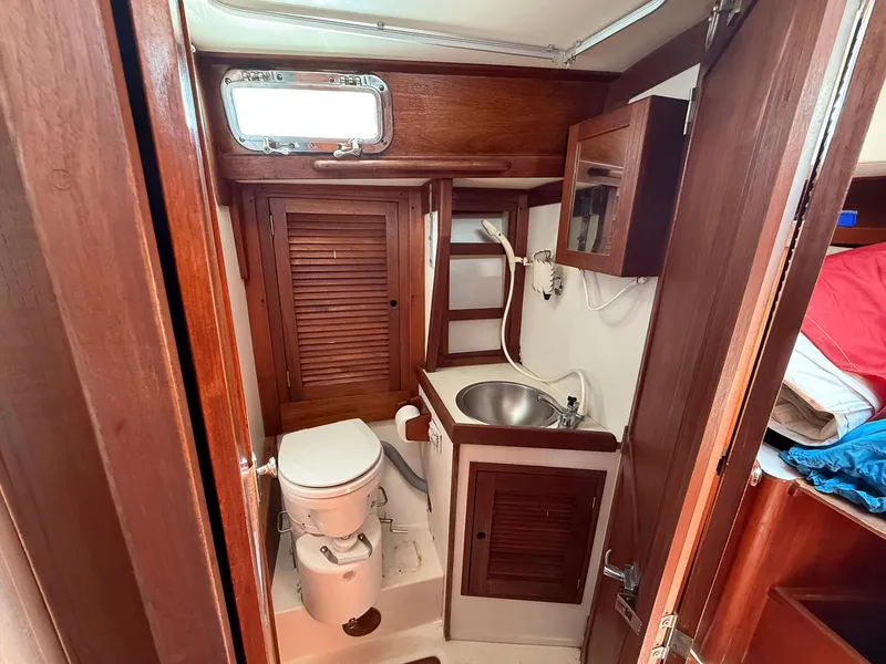 Slide: The Image of 1982 Tartan 37 yacht bathroom with wooden cabinetry, sink, and toilet. - 43