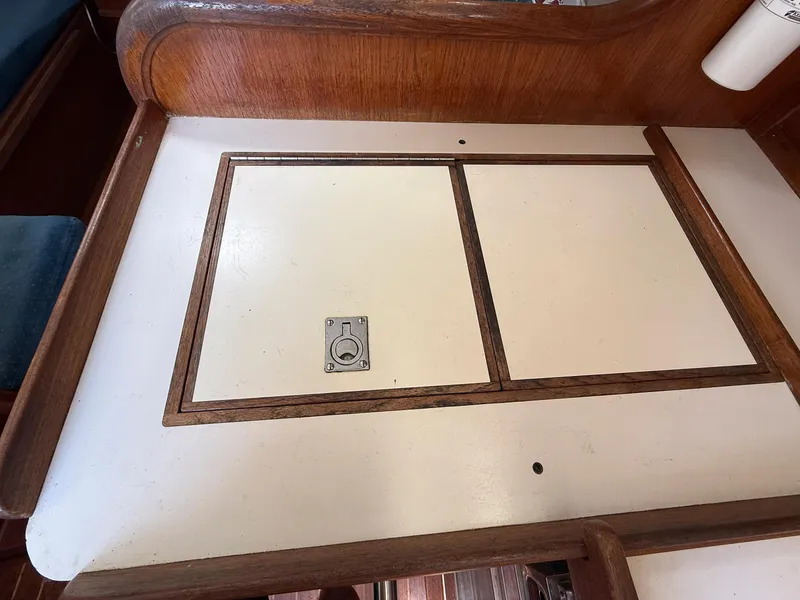 Slide: The Image of Wooden interior detail of a 1982 Tartan 37 sailboat, featuring a storage compartment. - 49