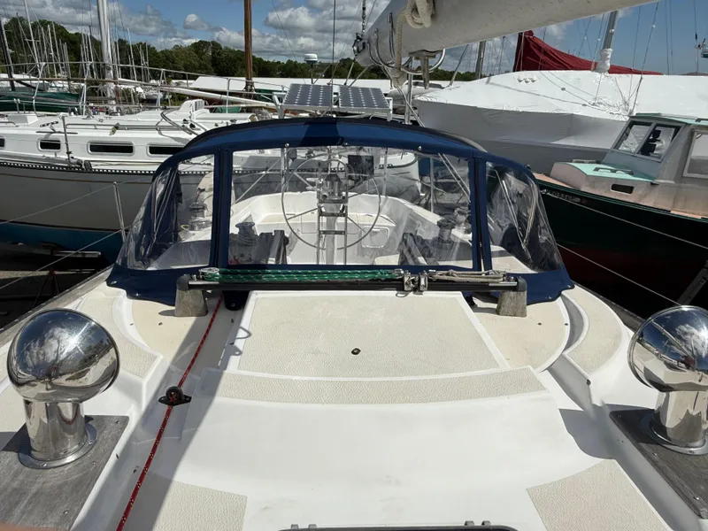 Slide: The Image of 1982 Tartan 37 sailboat cockpit with blue canopy, docked among other boats. - 6