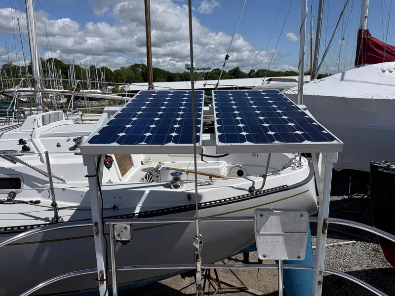 Slide: The Image of 1982 Tartan 37 sailboat with solar panels, docked under a partly cloudy sky. - 8