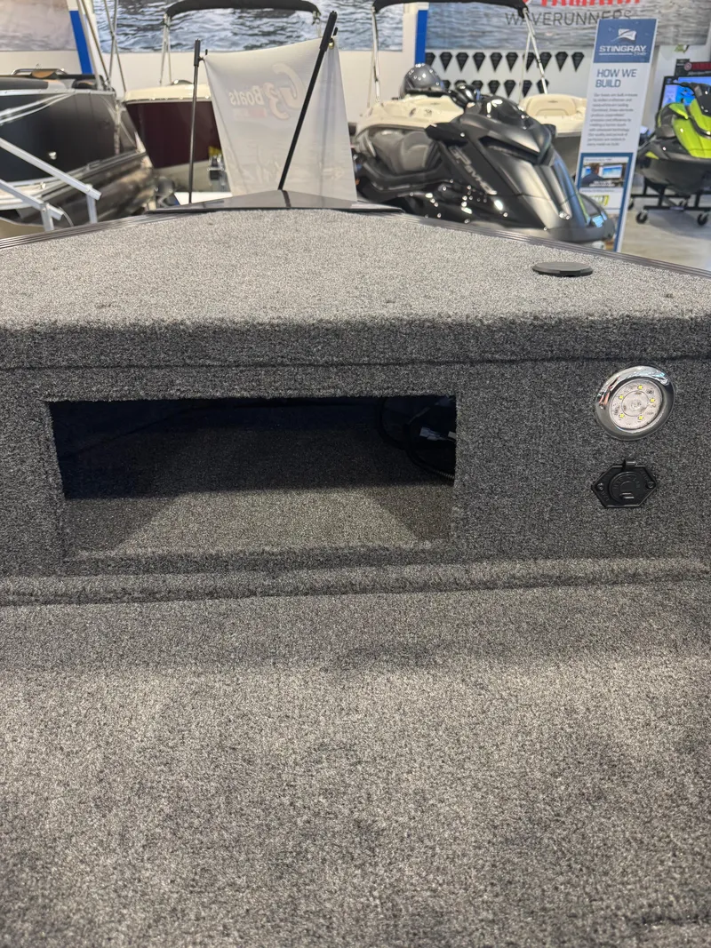Slide: The Image of Carpeted interior of 2025 G3 AV-164C boat, featuring storage compartment and control panel. - 9