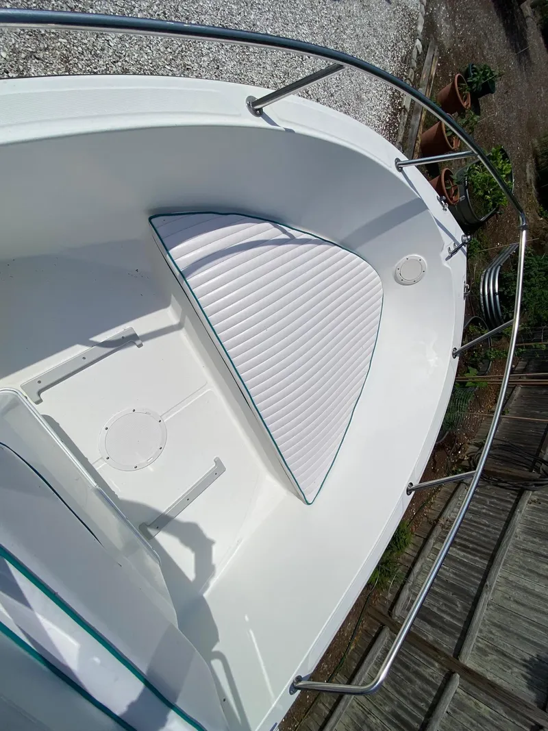 Slide: The Image of 1995 Edgewater Dougherty 1800 CC Marlin boat interior with cushioned seating and railings. - 13