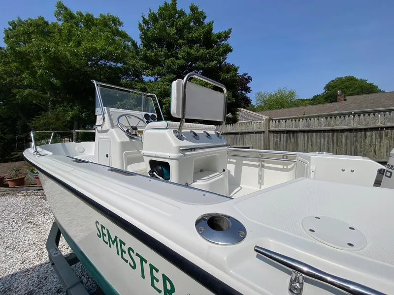Slide: The Image of 1995 Edgewater Dougherty 1800 CC Marlin boat in a yard, featuring a clean deck and console. - 6