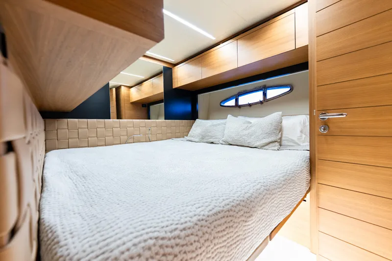Slide: The Image of Luxurious bedroom interior on a 2012 Pershing 92 yacht, featuring elegant wood finishes. - 13