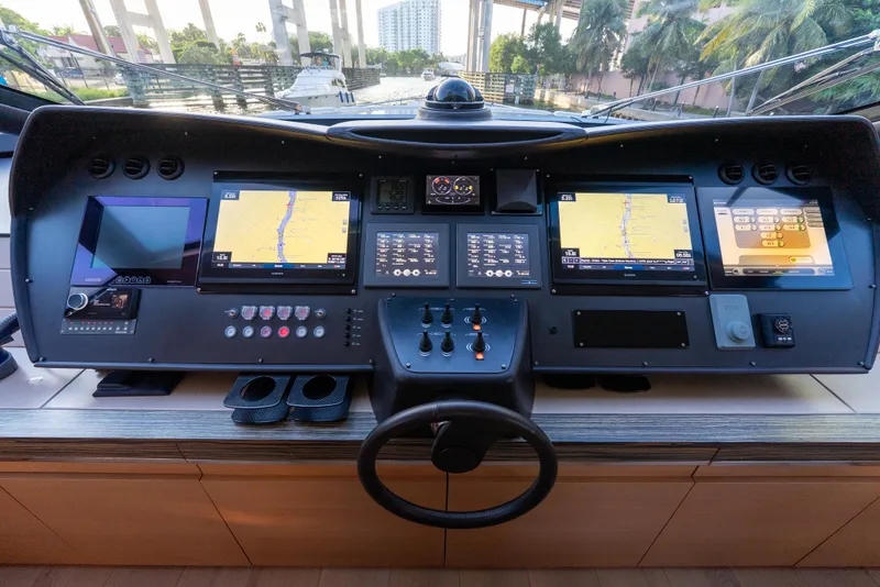 Slide: The Image of Control panel of a 2012 Pershing 92 yacht with navigation screens and steering wheel. - 33