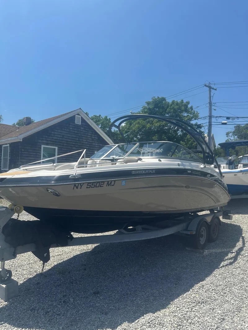 The Image of 2013 Yamaha Boats 242 Limited S on trailer, parked outdoors under clear blue sky. - 1