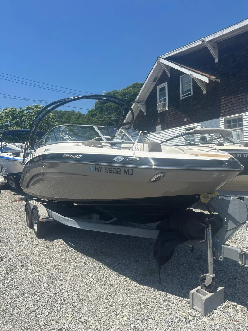 Slide: The Image of 2013 Yamaha Boats 242 Limited S on trailer, parked outdoors under clear blue sky. - 3