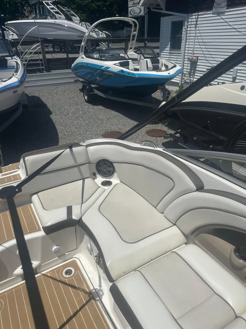 Slide: The Image of 2013 Yamaha Boats 242 Limited S interior with white seating and wood accents. - 8