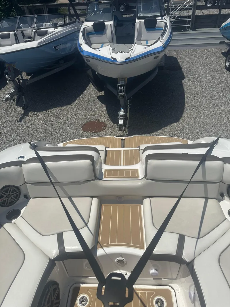 Slide: The Image of 2013 Yamaha Boats 242 Limited S interior with seating and deck, parked on gravel. - 9