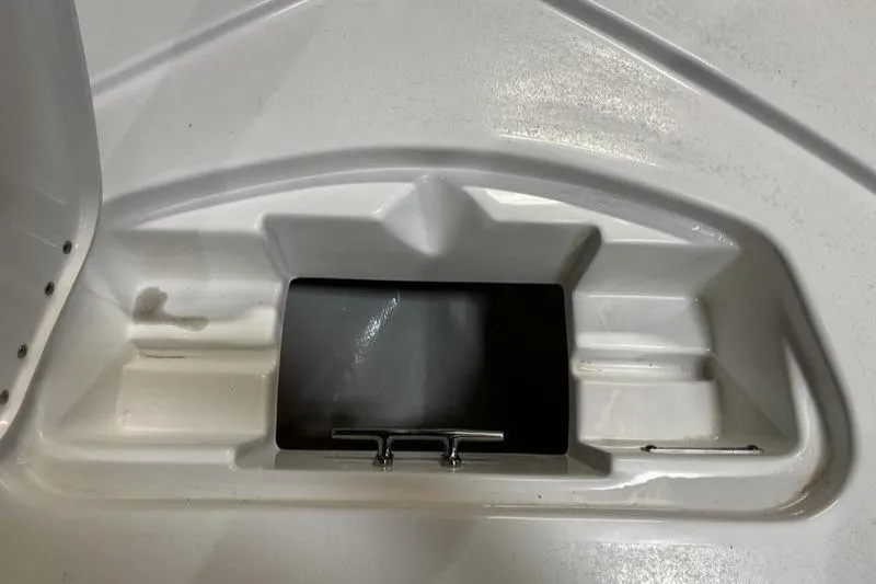 Slide: The Image of 2025 Tidewater 1910 Bay Max boat storage compartment, white interior with black hatch. - 17