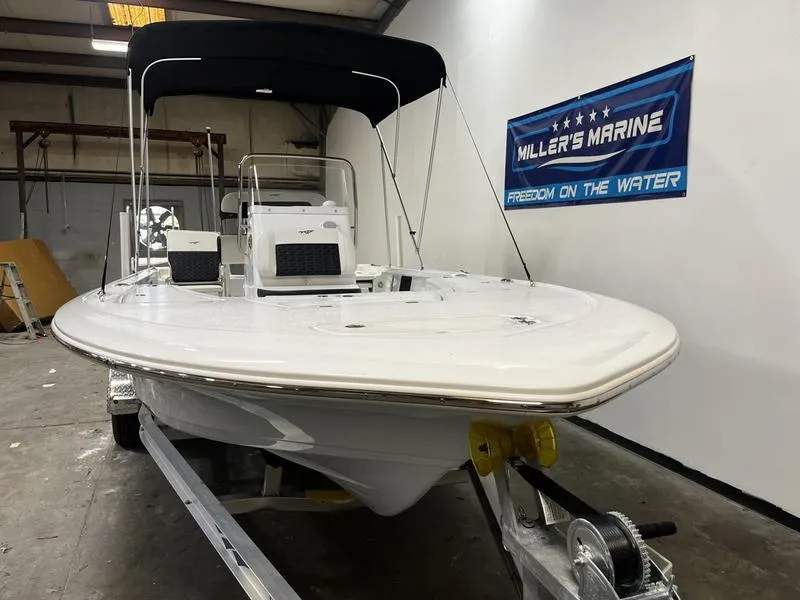 Slide: The Image of 2025 Tidewater 1910 Bay Max boat in showroom, featuring sleek design and bimini top. - 2