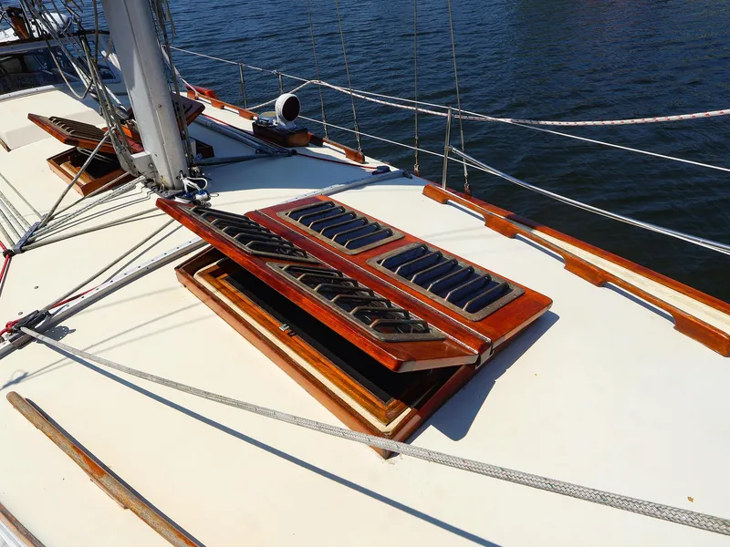 Slide: The Image of 1987 Gozzard 36 sailboat deck with open wooden hatches and rigging. - 13