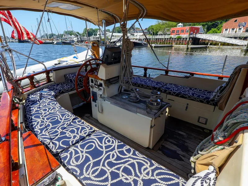 Slide: The Image of Cockpit of 1987 Gozzard 36 sailboat with nautical-themed cushions and marina view. - 22