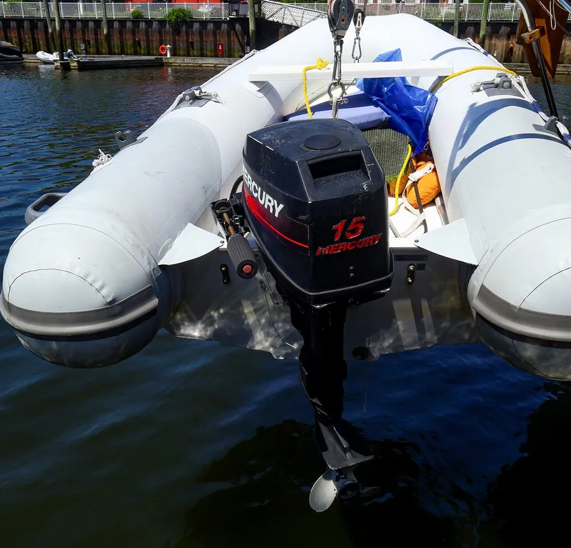 Slide: The Image of Inflatable boat with Mercury 15 outboard motor, docked near a Gozzard 36, 1987 model. - 25