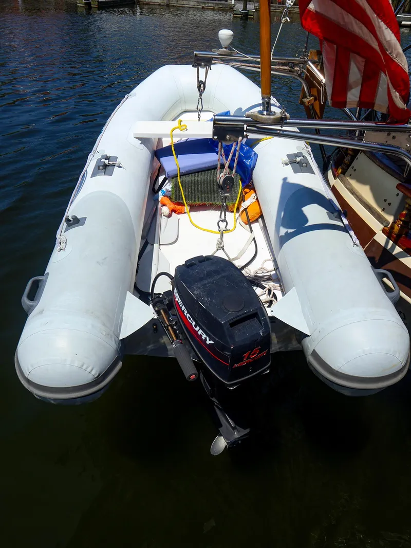 Slide: The Image of Inflatable boat with Mercury outboard motor, docked beside a Gozzard 36, 1987 model. - 26