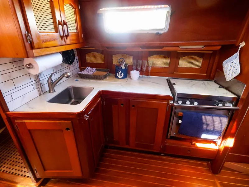 Slide: The Image of Cozy 1987 Gozzard 36 yacht kitchen with wooden cabinets and modern appliances. - 36