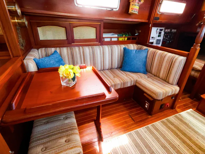 Slide: The Image of Cozy interior of 1987 Gozzard 36 sailboat with striped seating and wooden table. - 37