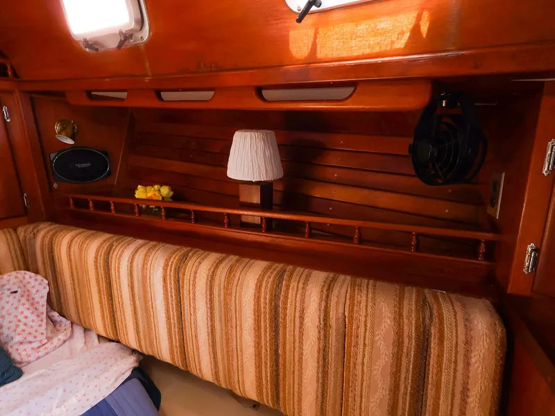 Slide: The Image of Cozy interior of 1987 Gozzard 36 sailboat with striped upholstery and wooden accents. - 39