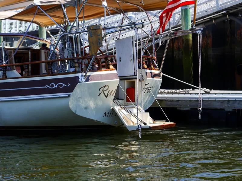 Slide: The Image of Sailboat Gozzard 36, 1987 model, docked with American flag, stern view. - 4