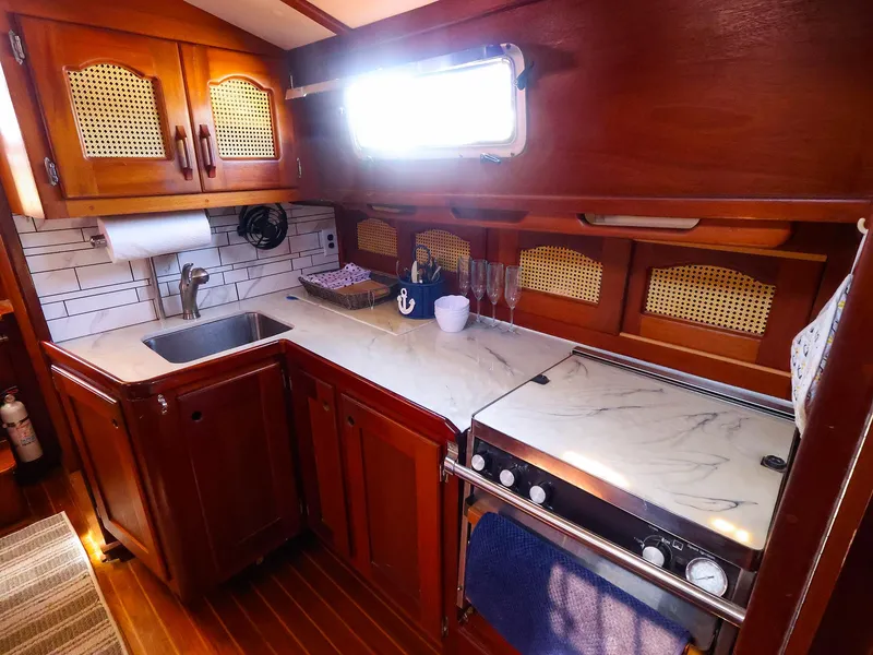 Slide: The Image of 1987 Gozzard 36 yacht kitchen with wooden cabinets and marble countertops. - 40