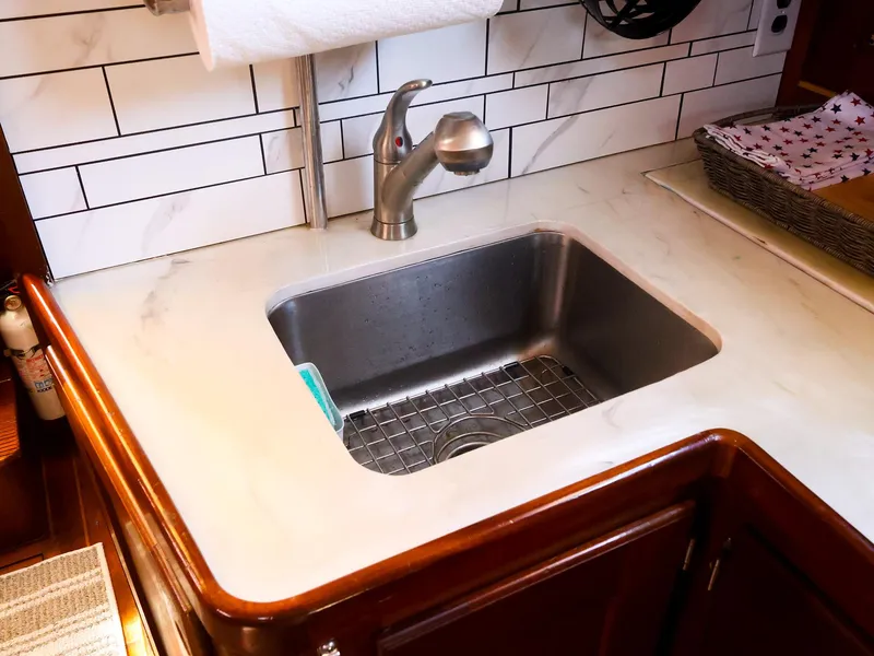Slide: The Image of 1987 Gozzard 36 yacht kitchen sink with modern faucet and tiled backsplash. - 43