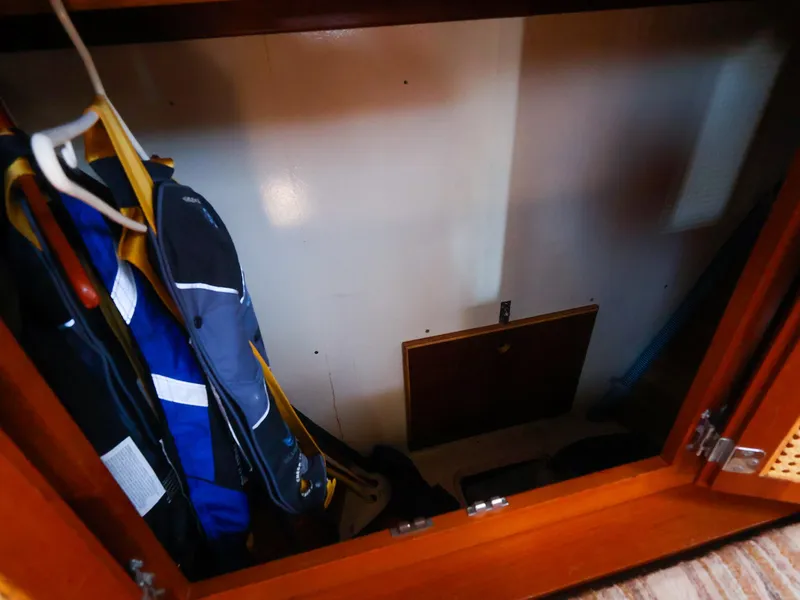 Slide: The Image of Cabinet interior on 1987 Gozzard 36 sailboat with hanging jackets. - 44