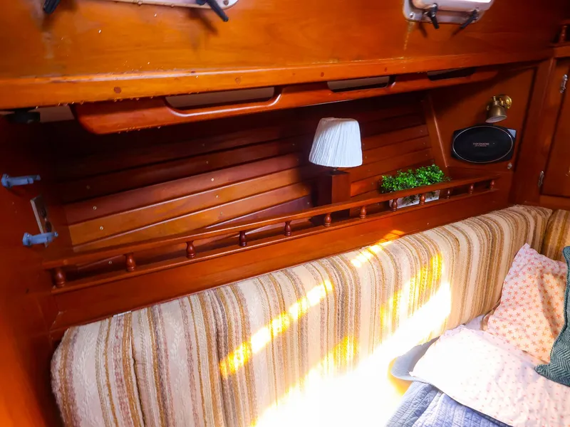 Slide: The Image of Interior of 1987 Gozzard 36 sailboat with wooden shelves and striped upholstery. - 47