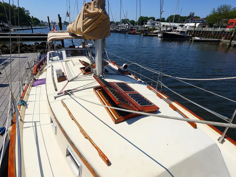 Slide: The Image of 1987 Gozzard 36 sailboat docked at a marina, showcasing its deck and rigging. - 5