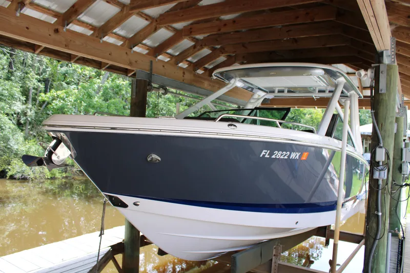 The Image of 2021 Chaparral 280 OSX boat docked under wooden shelter. - 0