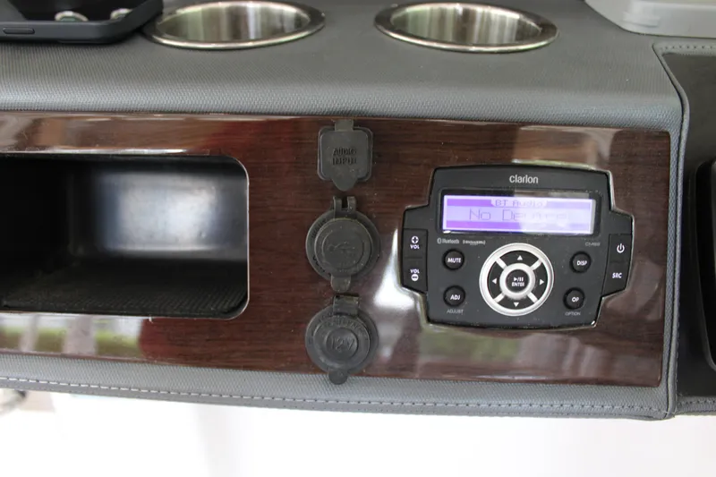 Slide: The Image of 2021 Chaparral 280 OSX dashboard with Clarion audio system and cup holders. - 21