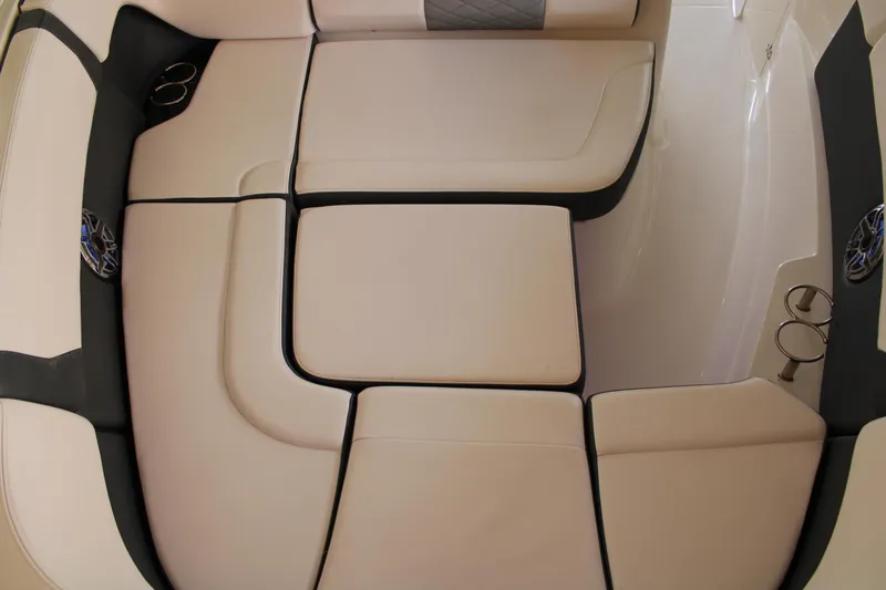 Slide: The Image of 2021 Chaparral 280 OSX boat interior with beige cushioned seating and cup holders. - 24