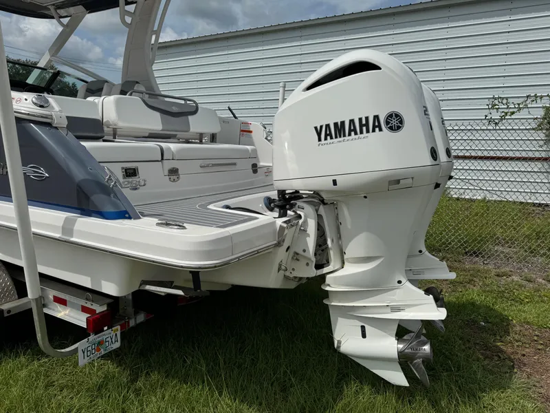 Slide: The Image of 2021 Chaparral 280 OSX boat with Yamaha outboard motor, parked on grass. - 34