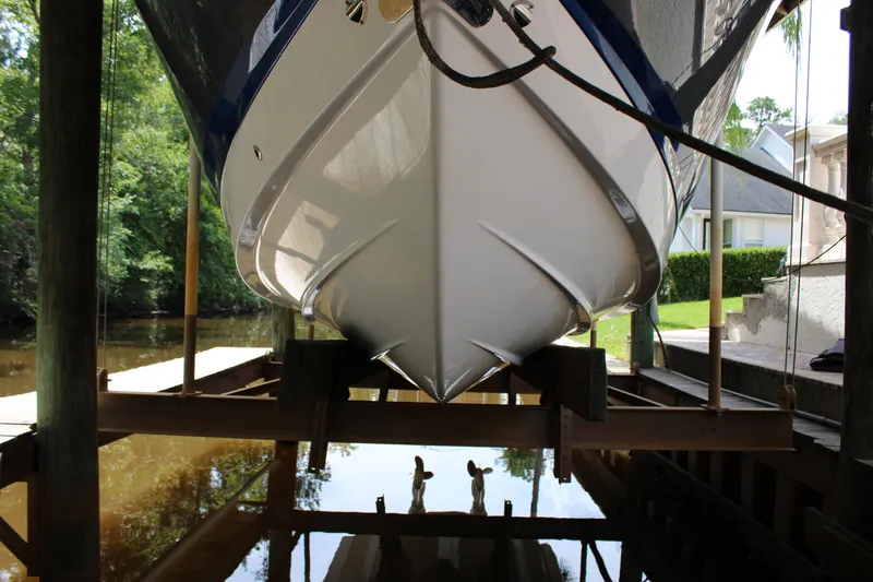 Slide: The Image of 2021 Chaparral 280 OSX boat hull in dock, reflecting on calm water. - 5