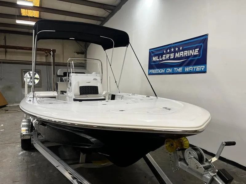 Slide: The Image of 2025 Tidewater 1910 Bay Max boat in showroom, featuring sleek design and canopy. - 2