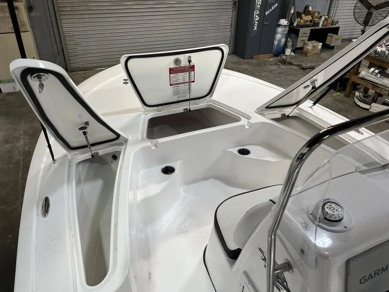 Slide: The Image of 2025 Tidewater 1910 Bay Max boat interior with open storage compartments in a garage setting. - 10
