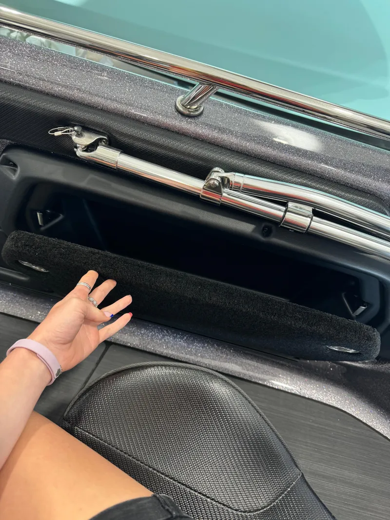 Slide: The Image of Open storage compartment in 2025 Skeeter Solera 189 boat, with hand reaching inside. - 22