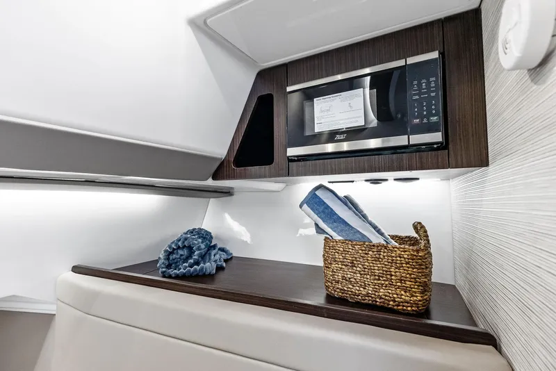 Slide: The Image of 2026 Everglades 367 CX boat interior with seating and storage, docked at marina. - 11