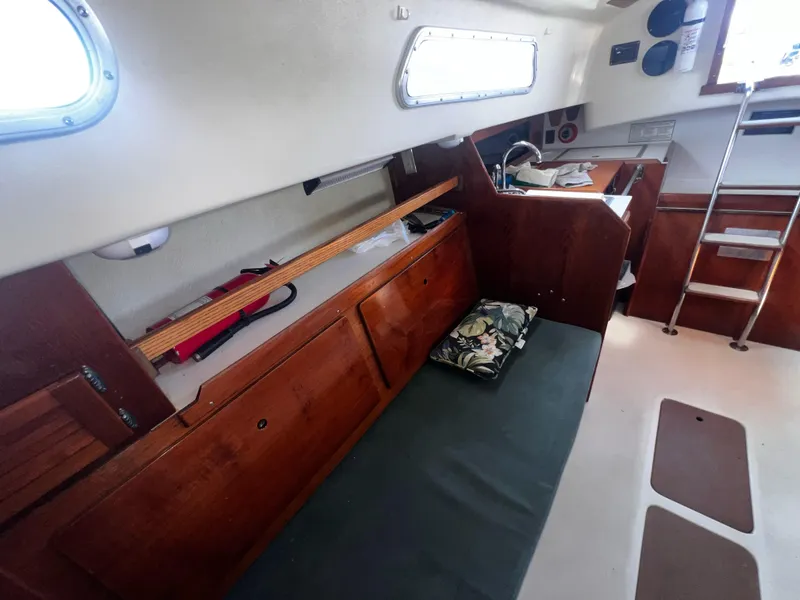 Slide: The Image of Interior of a 1980 Pearson 32 sailboat with wooden cabinetry and seating area. - 12