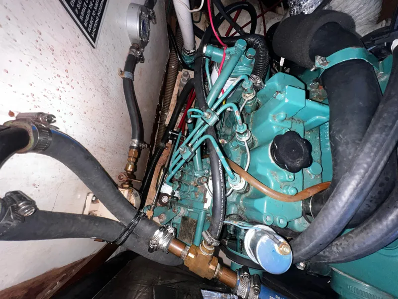 Slide: The Image of Engine compartment of a 1980 Pearson 32 sailboat, featuring hoses and mechanical components. - 18