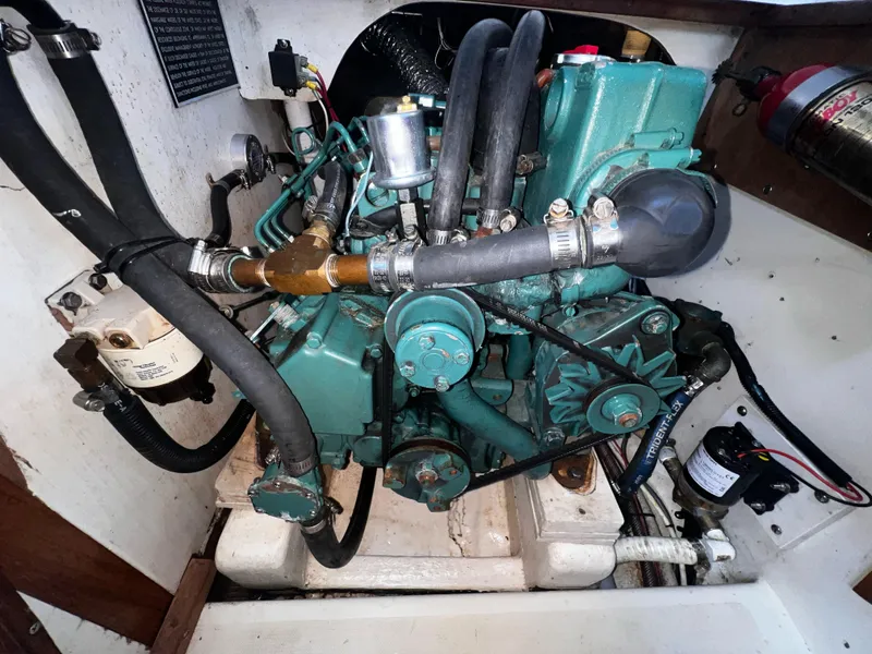 Slide: The Image of Engine compartment of a 1980 Pearson 32 sailboat, featuring hoses and mechanical components. - 23