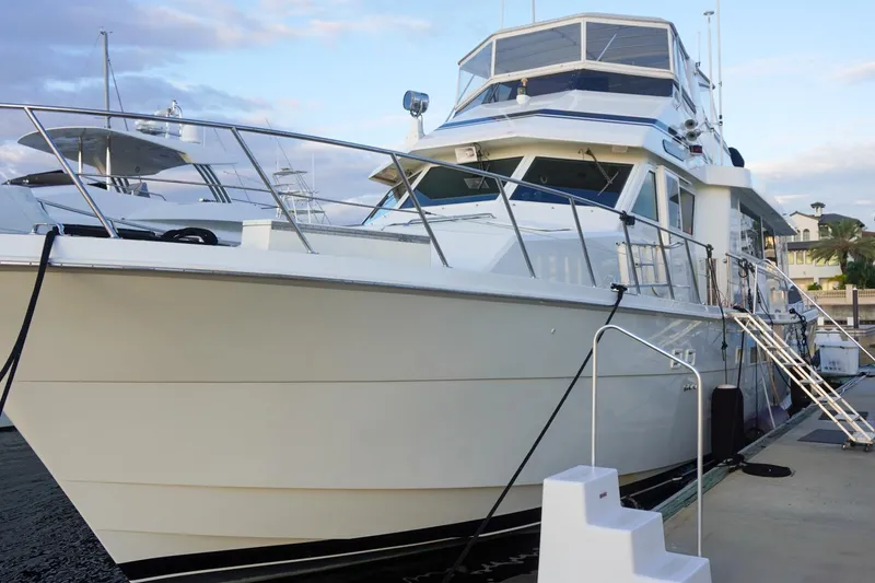 Slide: The Image of 1990 Hatteras 62 Cockpit Motor Yacht docked at marina under blue sky. - 10