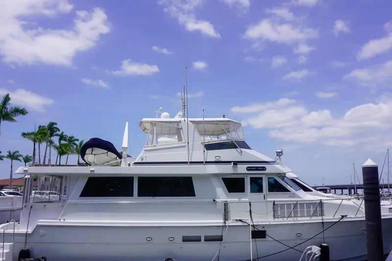 Slide: The Image of 1990 Hatteras 62 Cockpit Motor Yacht docked under a clear blue sky. - 11