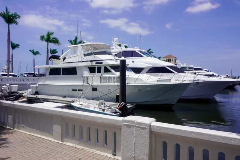 Slide: The Image of 1990 Hatteras 62 Cockpit Motor Yacht docked at marina under blue sky. - 12