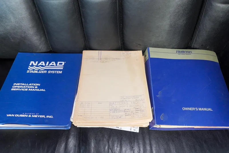 Slide: The Image of Manuals for 1990 Hatteras 62 Cockpit Motor Yacht and Naiad Stabilizer System on leather seat. - 16