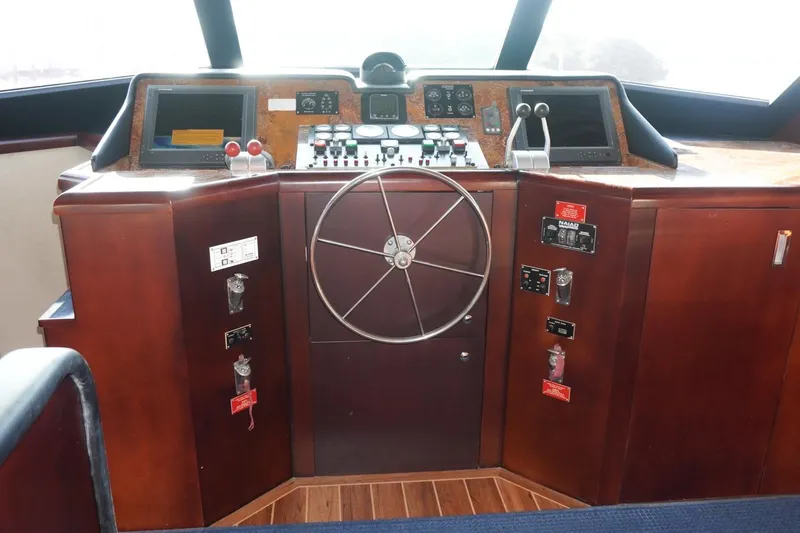 Slide: The Image of Cockpit of 1990 Hatteras 62 Cockpit Motor Yacht with steering wheel and control panels. - 19