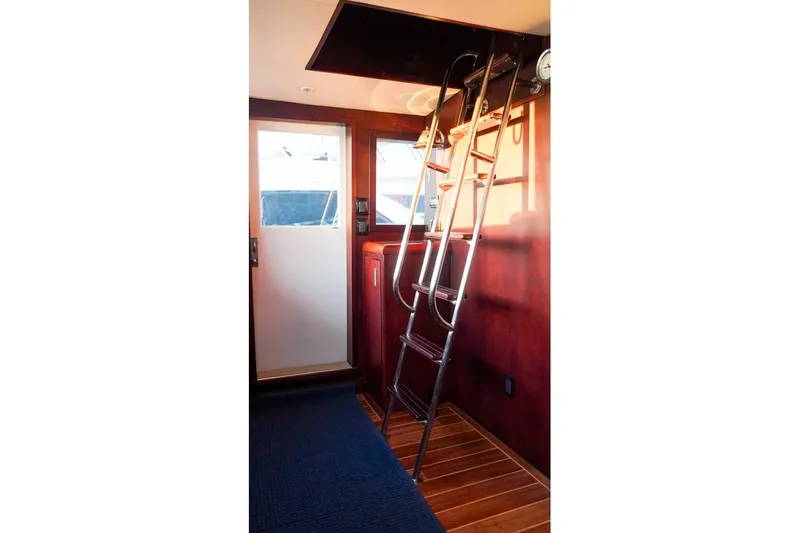 Slide: The Image of Interior of 1990 Hatteras 62 Cockpit Motor Yacht with ladder and wooden flooring. - 20