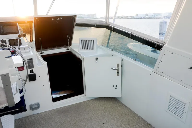 Slide: The Image of 1990 Hatteras 62 Cockpit Motor Yacht interior with open hatch and control panel. - 21