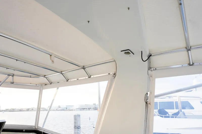 Slide: The Image of Interior view of 1990 Hatteras 62 Cockpit Motor Yacht, featuring windows and metal framework. - 27